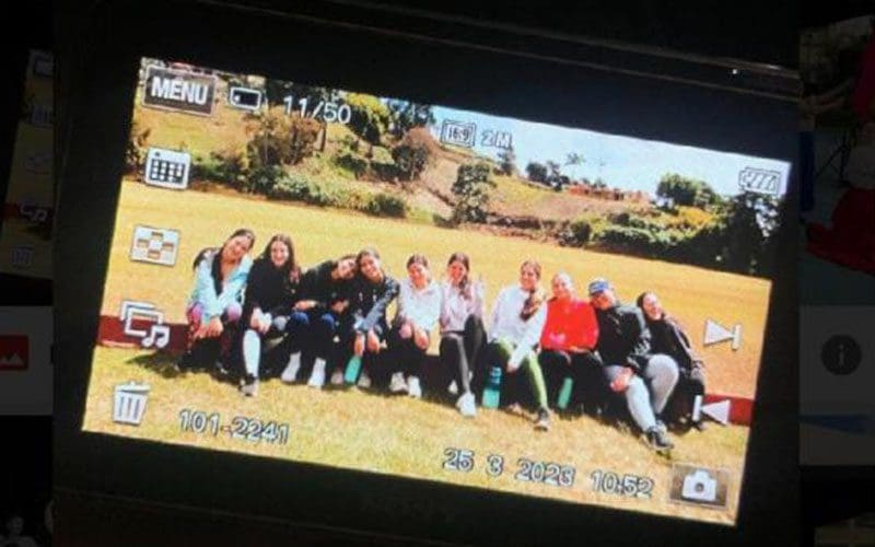 A group of people sitting on top of a field.