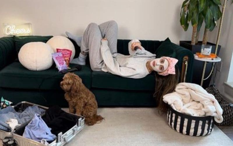 A woman laying on the couch with her dog