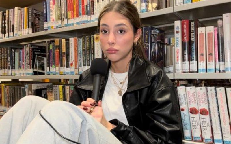 A woman sitting in front of some books