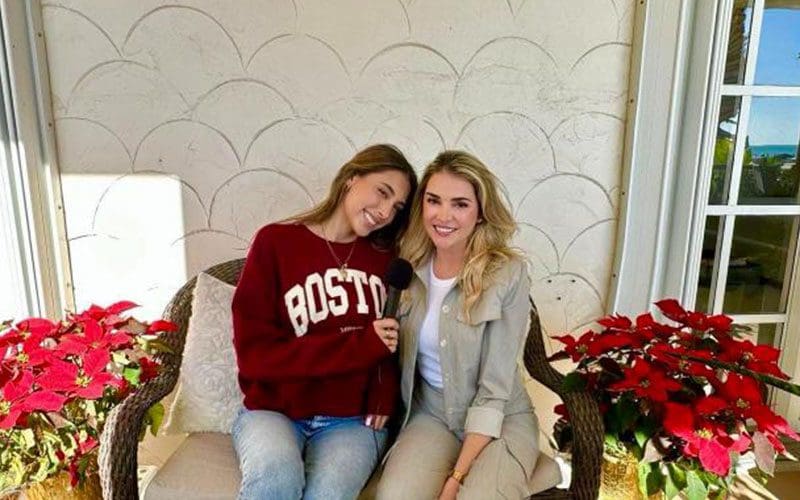 Two women sitting on a couch posing for the camera.