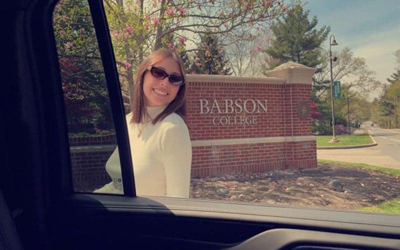 A woman in sunglasses standing outside of a building.