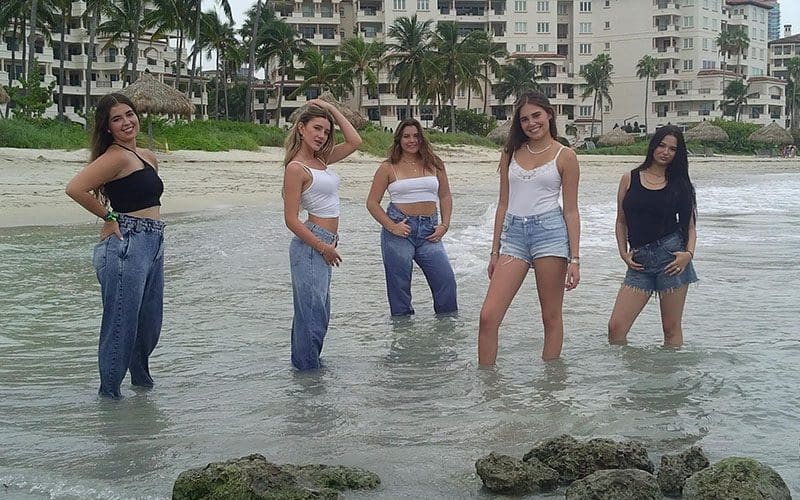 A group of women standing in the water.