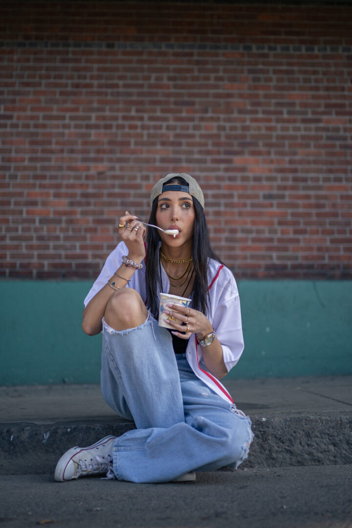 A woman sitting on the ground eating food.