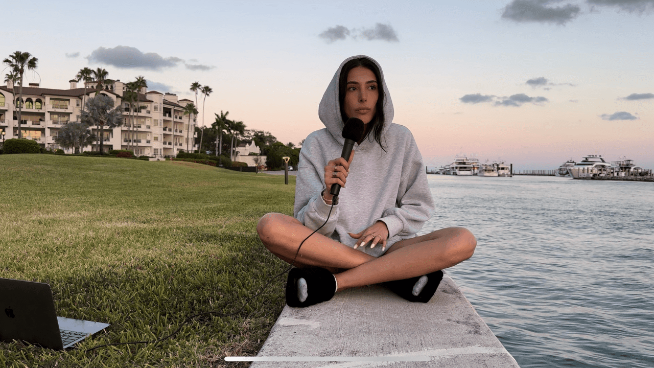 A person sitting on the ground near water.